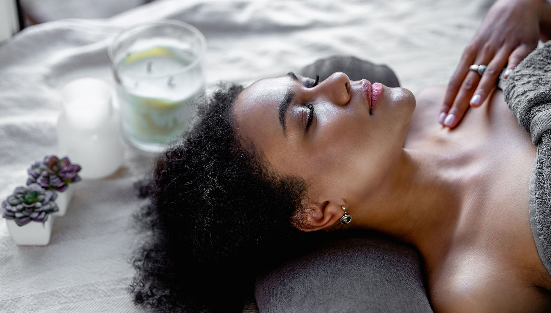 Woman receiving gentle manual lymphatic drainage massage for detox and glowing skin in Palm Beach County home.